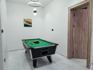 una mesa de ping pong en una habitación junto a una puerta en LPMD Apartment, en Ikuata