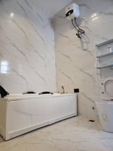 Un baño con bañera blanca y una cámara en la pared. en LPMD Apartment, en Ikuata