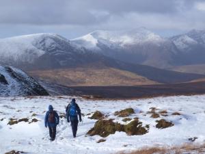 two people walking down a snow covered mountain at Holiday Home Dingle CY No 5 - TR4 - 2 Bed - Sleeps 4 by Interhome in Dingle