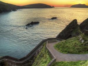 a stairway leading into a body of water at sunset at Holiday Home Dingle CY No 5 - TR4 - 2 Bed - Sleeps 4 by Interhome in Dingle
