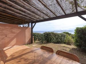 eine Terrasse mit einem Holztisch und 2 Stühlen in der Unterkunft Holiday Home Villa 12 by Interhome in SantʼAmanza