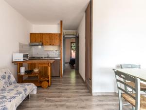 eine Küche und ein Wohnzimmer mit einer Couch und einem Tisch in der Unterkunft Holiday Home Villa 12 by Interhome in SantʼAmanza