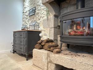 a fireplace in a living room with a stove at Maison de bourg 3 chambres in Bérus