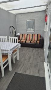 una sala de estar con un sofá y una mesa en Chapel Point Holiday Lets, en Chapel St. Leonards