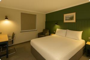 バーミンガムにあるPairc House Hotelのベッドルーム(白いベッド1台、デスク、椅子付)