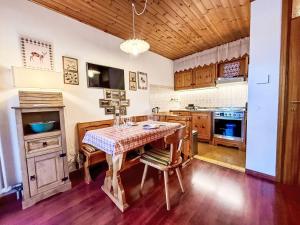 a kitchen with a table with chairs in it at Apartment Marmolada-12 by Interhome in Alba di Canazei