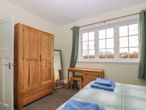 a bedroom with a bed and a window and a desk at Bankhead Of Lour Bungalow in Kingsmuir