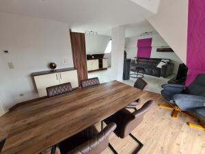 a living room with a large wooden table and chairs at Moritz Apartments - Pfarrgasse 09 in Küllstedt