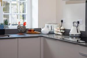 a kitchen with a chicken standing on a counter at The Dower House at Solsgirth Home Farm in Dollar