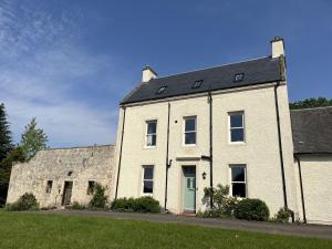 a large white brick house with a black roof at The Farmhouse at Solsgirth Home Farm in Dollar