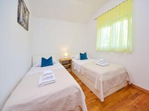 two twin beds in a room with a window at Holiday Home Marija by Interhome in Primorski Dolac
