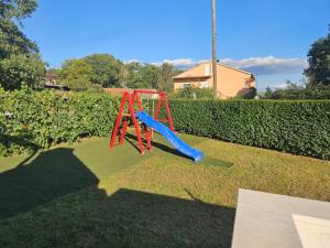 a red slide on the grass in a yard at Holiday Home Marija by Interhome in Primorski Dolac