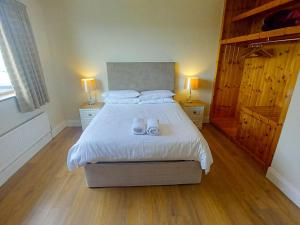 a bedroom with a bed with two white shoes on it at Holiday Home Behy Lodge Glenbeigh by Interhome in Behy Bridge
