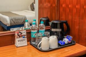 a tray with water bottles and cups on a table at asar CP Outer Circle by Orion Hotels in New Delhi