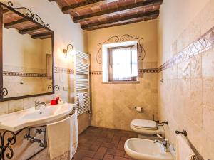 a bathroom with a sink and a toilet and a mirror at Villa La Salciaia-1 by Interhome in Marciano +20 photos