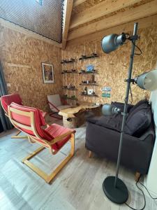 ein Wohnzimmer mit einer Lampe, einem Sofa und einem Stuhl in der Unterkunft Logement près de la rivière in Athée