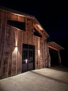 eine hölzerne Scheune mit einer Tür bei Nacht in der Unterkunft Logement près de la rivière in Athée