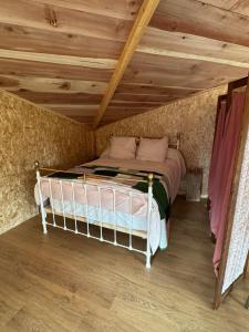 ein Bett in einem Zimmer mit Holzdecke in der Unterkunft Logement près de la rivière in Athée