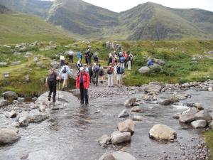 a group of people walking across a stream at Apartment Grove Lodge No 5 - 2 Bed by Interhome in Killorglin