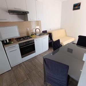 a kitchen with a stove and a table with chairs at Lana2 in Starigrad-Paklenica +10 photos