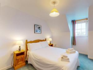 a bedroom with a white bed and a window at Holiday Home Ballybunion - TR4 HC NO 7 by Interhome in Ballybunion +9 photos