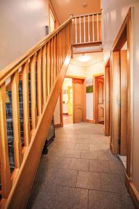 a hallway with wooden stairs in a house at Holiday Home Benderloch House & Frobost Lodge by Interhome in Daliburgh