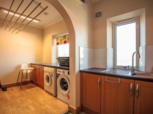a kitchen with a washer and dryer and a sink at Holiday Home Benderloch House & Frobost Lodge by Interhome in Daliburgh