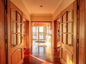 a hallway with wooden doors and aoyer with a rug at Holiday Home Benderloch House & Frobost Lodge by Interhome in Daliburgh