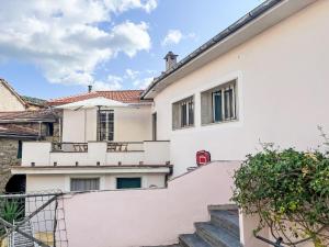 una casa blanca con escaleras y un buzón rojo en Apartment Ca'de scia Biancotta by Interhome, en Prela'