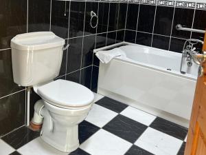 a bathroom with a white toilet and a bath tub at Holiday Home Castle Quay - TR4 HH No 14 by Interhome in Barrel Cross Roads +12 photos