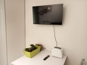 ein Fernseher an der Wand mit einem Tisch mit einem Toaster in der Unterkunft Central Plaza Cozy Studio accesso diretto alle piste in Sauze d'Oulx + 7 Fotos