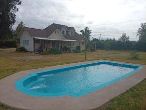 a large swimming pool in front of a house at Parcela en Mallarauco in Melipilla