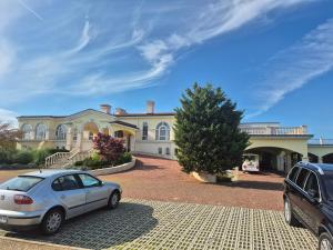 ein vor einem großen Haus geparkt in der Unterkunft New Light house golf apartment in Baltschik + 5 Fotos