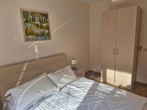 ein Schlafzimmer mit einem Bett und einem Gemälde an der Wand in der Unterkunft New Light house golf apartment in Baltschik