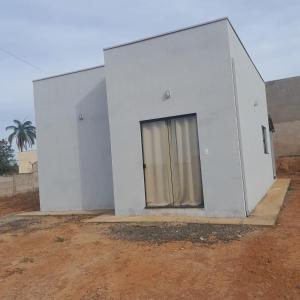 a white building with a window in a field at Casa aconchegante in Delfinópolis