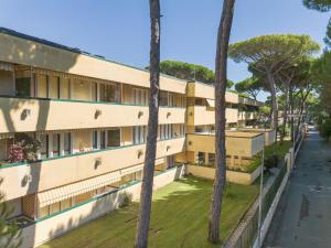 an apartment building with palm trees in the foreground at Apartment Appartamento Residence Henderson by Interhome in Cinquale