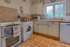 uma cozinha com máquina de lavar e secar roupa em Foxgloves -Cosy Retreat in the Heart of Hunstanton, Crabpot Cottages em Hunstanton mais 7 fotografias