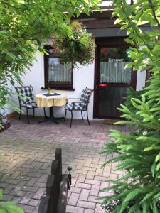 a patio with two chairs and a table in front of a building at Pension Forstgut Waldeck in Ingelheim am Rhein