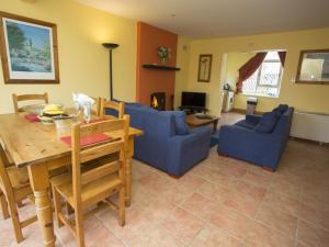 a living room with a blue couch and a table at Holiday Home Willow Grove HC No- 4 by Interhome in Mervyn