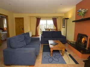 a living room with blue couches and a fireplace at Holiday Home Willow Grove HC No- 4 by Interhome in Mervyn