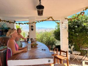 two women sitting at a table on a patio at Casa Bambú Boutique Studios Andalusië with pool and Mountain Views in Vélez-Málaga +73 photos