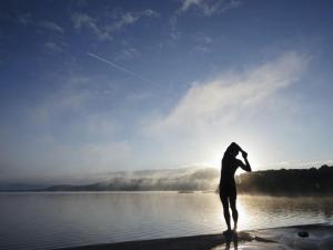 uma pessoa de pé numa praia com um papagaio em Holiday Home Lakeside HH - FRI - TR1-4Type B No 7 by Interhome em Killaloe