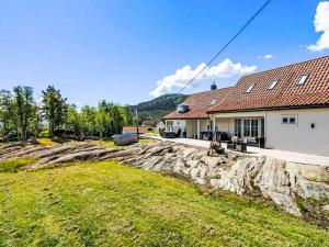 een huis met een stenen muur voor een tuin bij Holiday Home Holmen by Interhome in Bakka