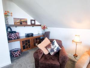 uma sala de estar com um sofá e uma cadeira em Holiday Home Riverrun Holiday Homes No 15 by Interhome em Raheelan