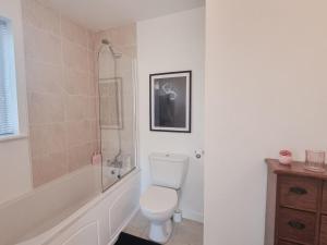 um banheiro branco com vaso sanitário e chuveiro em Holiday Home Riverrun Holiday Homes No 15 by Interhome em Raheelan mais 38 fotografias