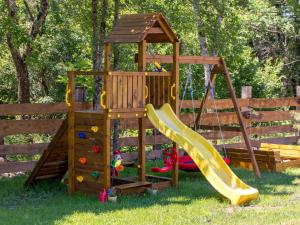 a wooden playground with a slide and a swing at Holiday Home Relax Lika by Interhome in Tomingaj