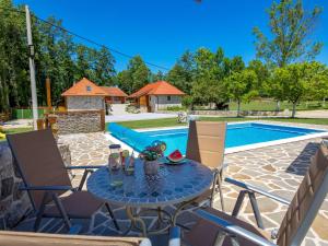 a patio with a table and chairs and a pool at Holiday Home Relax Lika by Interhome in Tomingaj