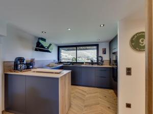 a kitchen with blue cabinets and a sink and a window at Chalet rénové 10 personnes à Tignes, sauna inclus - FR-1-641-121 in Tignes