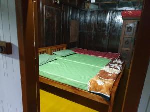 une chambre avec un lit avec une couette verte dans l'établissement Nutmeg nirvana, à Erāttupetta