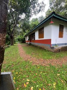 une maison avec un rouge et un blanc dans l'établissement Nutmeg nirvana, à Erāttupetta
